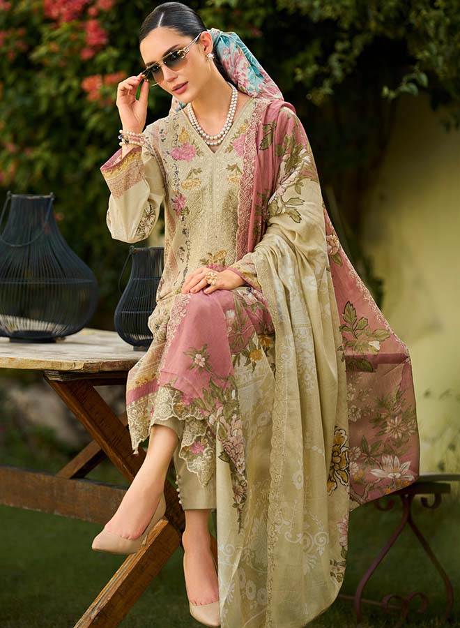 Model wearing a floral Pakistani cotton suit with neck and daman embroidery, matching trousers and a mal mal dupatta.